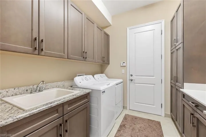 Gotta love a laundry room with a linen closet, folding area, and sink