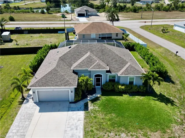 View of front of home with glass enclosure, stucco siding, driveway, and a garage