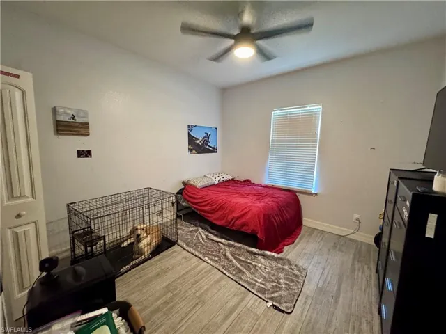 Bedroom with baseboards, ceiling fan, and wood finished floors
