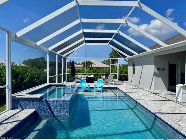 View of pool with a pool with connected hot tub, a lanai, and a patio