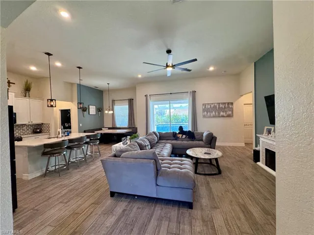 Living room featuring dark wood-style flooring, recessed lighting, and ceiling fan