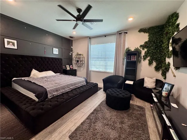 Bedroom featuring visible vents, wood finished floors, and a ceiling fan
