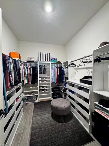 Walk in closet featuring wood finish floors