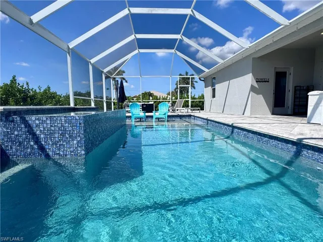 Outdoor pool featuring glass enclosure and a patio area