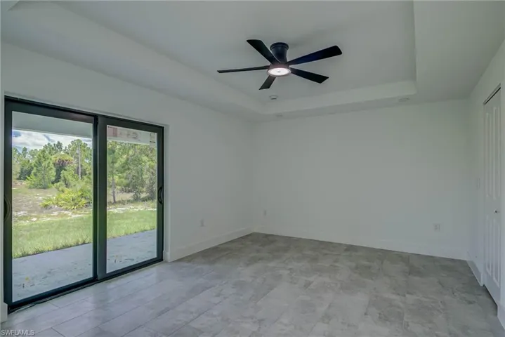 Spare room with a raised ceiling and a ceiling fan