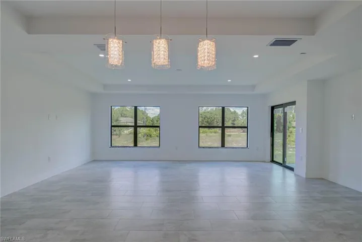 Unfurnished room featuring a raised ceiling and recessed lighting