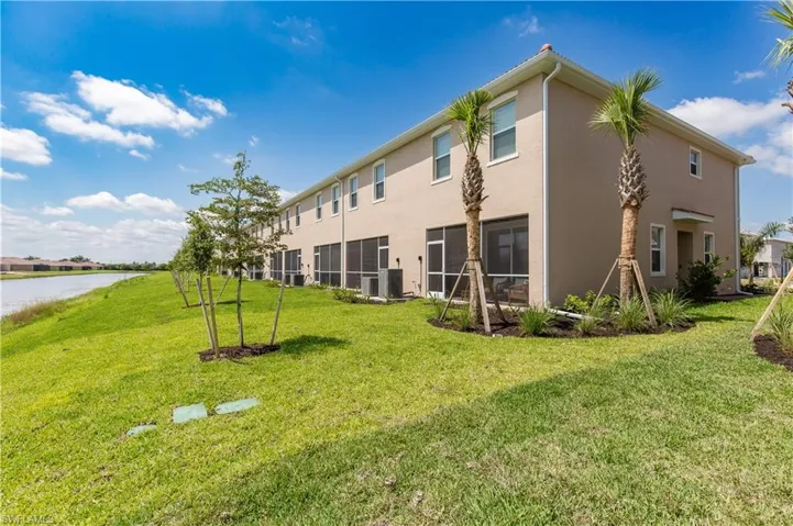 Back of house featuring central AC and a yard