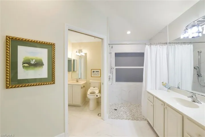 Primary bathroom and private water closet with pocket door.