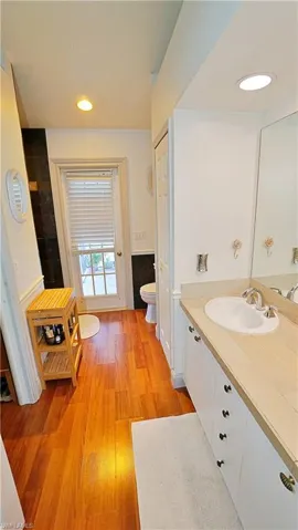 Bathroom featuring wood-type flooring, vanity, and toilet