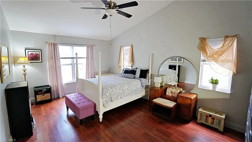 Bedroom with high vaulted ceiling, ceiling fan, and wood-type flooring