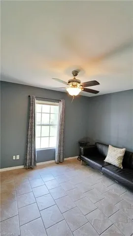 Unfurnished room featuring ceiling fan and light tile floors