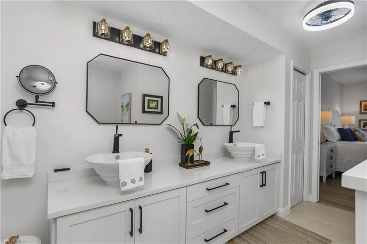 Full bathroom featuring double vanity, ensuite bath, and light tile patterned floors