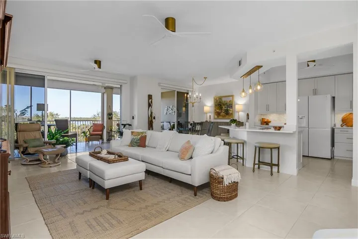 Living area featuring a ceiling fan, hanging lights, and light tile patterned floors