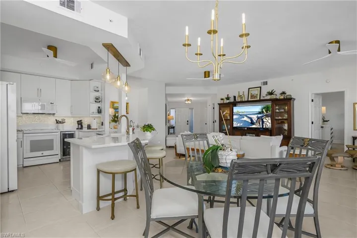 Dining space featuring a ceiling fan, wine cooler, and light tile patterned flooring