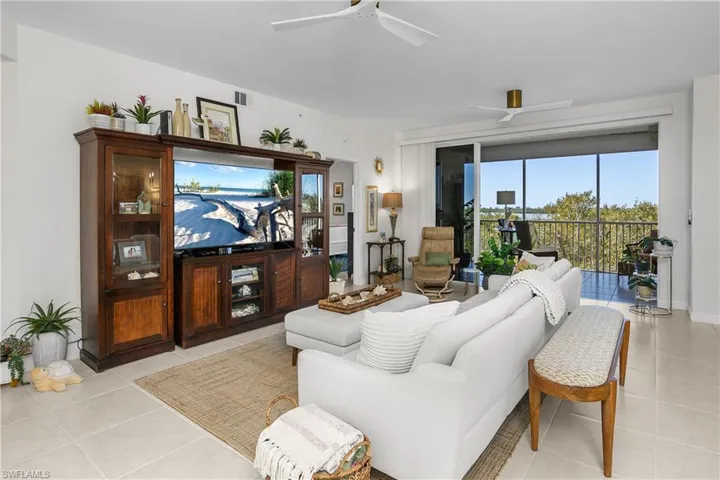 Living room with ceiling fan and light tile patterned floors