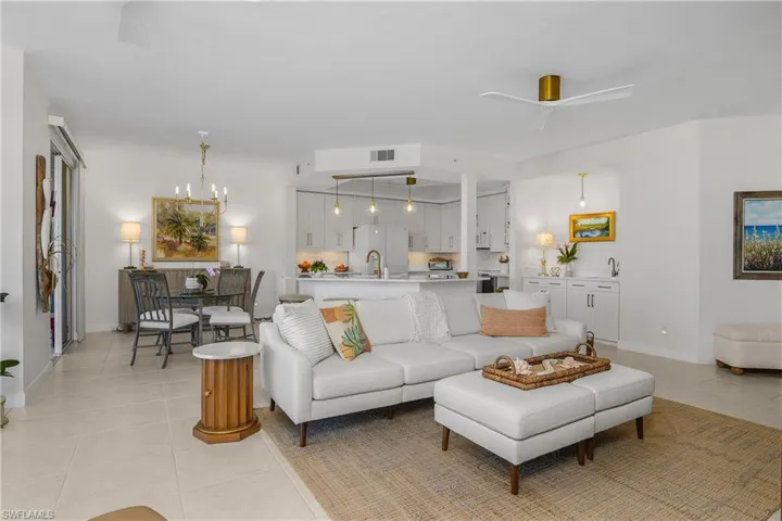 Living area with a ceiling fan, light tile patterned flooring, and suspended lighting