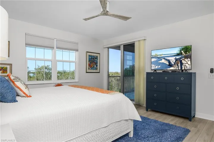 Bedroom with access to exterior, light wood-type flooring, and ceiling fan