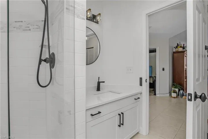 Bathroom with vanity, a stall shower, and light tile patterned flooring