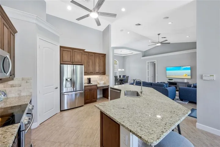 Kitchen featuring stainless steel appliances, sink, an island with sink, and tasteful backsplash