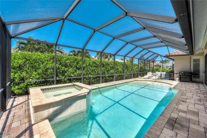 View of swimming pool with a patio area, a lanai, area for grilling, and an in ground hot tub