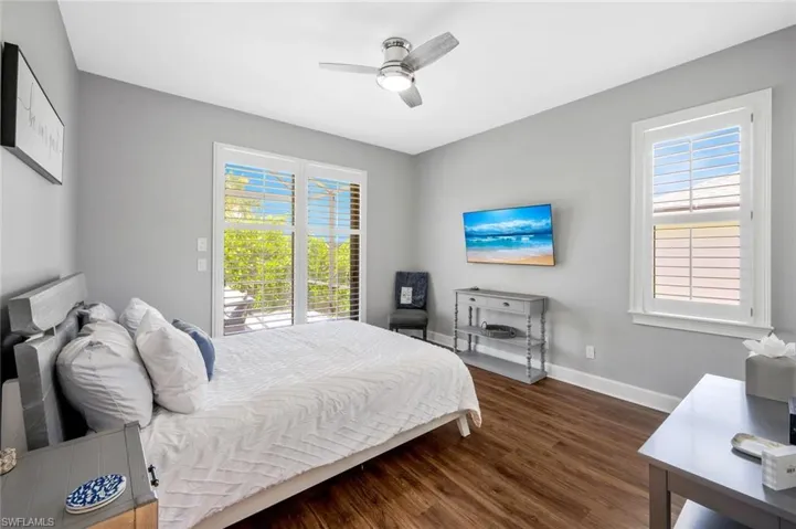 Bedroom with dark hardwood / wood-style floors and ceiling fan