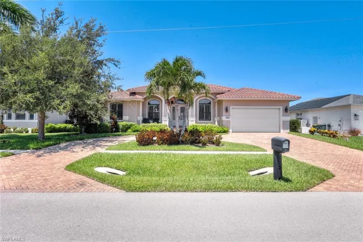 Mediterranean / spanish-style home with a front lawn and a garage