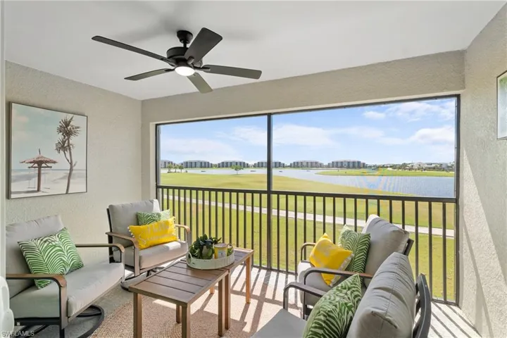 Sunroom with golf course view and a water view