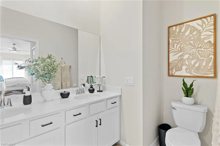 Ensuite bathroom with double vanity and a ceiling fan