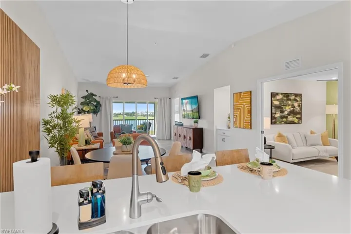 Kitchen featuring open floor plan, vaulted ceiling, and hanging light fixtures