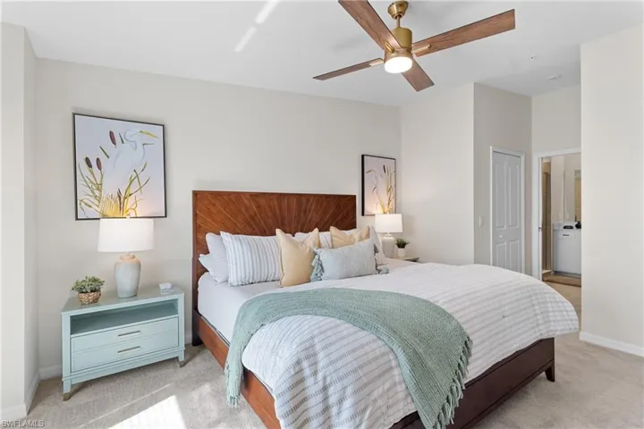 Bedroom featuring light carpet, ceiling fan, a closet, and connected bathroom