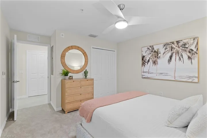Carpeted bedroom featuring ceiling fan and a closet