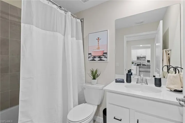 Bathroom featuring vanity and shower / tub combo with curtain