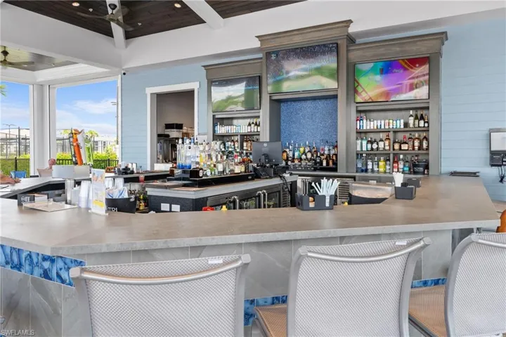 Community bar area featuring open shelves, light countertops, and wooden ceiling