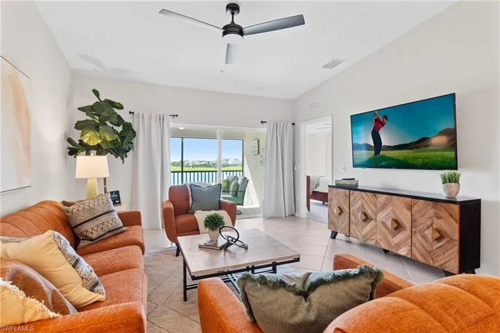 Living area with ceiling fan and light tile patterned flooring