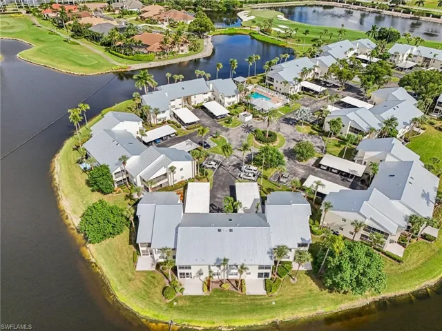 Aerial view of property's location featuring a large body of water, a golf club, and nearby suburban area