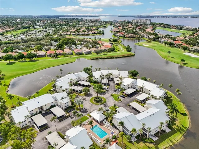 Aerial perspective of suburban area with a golf course and a nearby body of water
