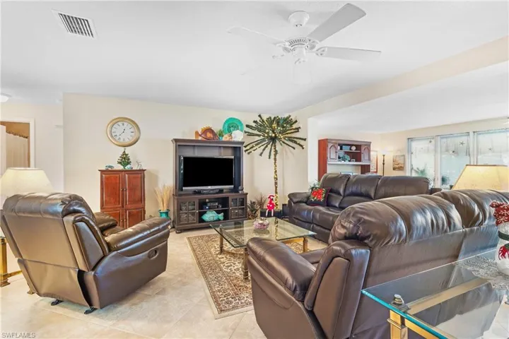 Tiled living room and view of sliders to screened pool area