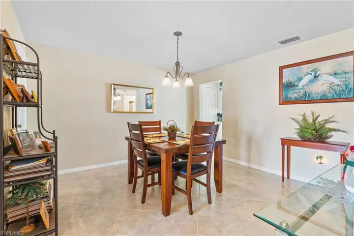 Dining space featuring light tile patterned flooring and a chandelier