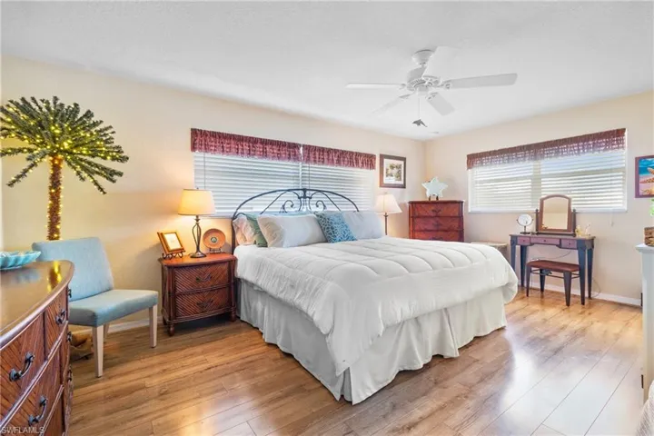 Large Master Bedroom wealth of natural light, featuring light wood-type flooring and ceiling fan