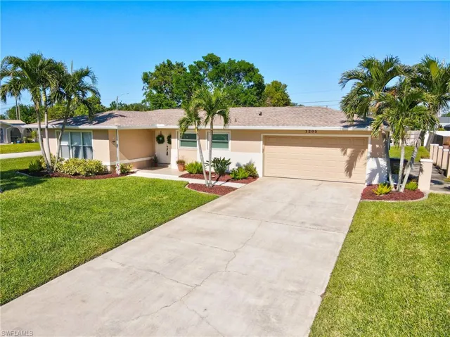 Ranch-style home featuring a front lawn and a garage
