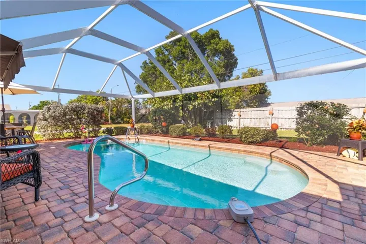 View of swimming pool with screened lanai