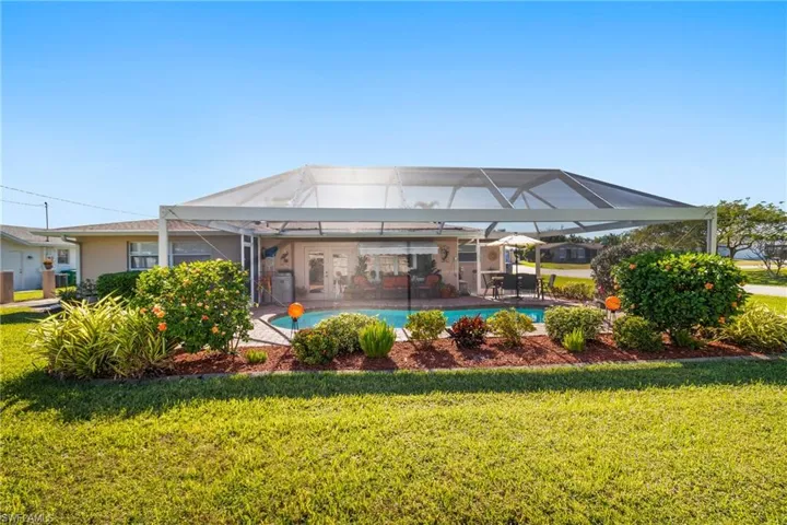 Back of house featuring a screened pool and, patio area, and a yard