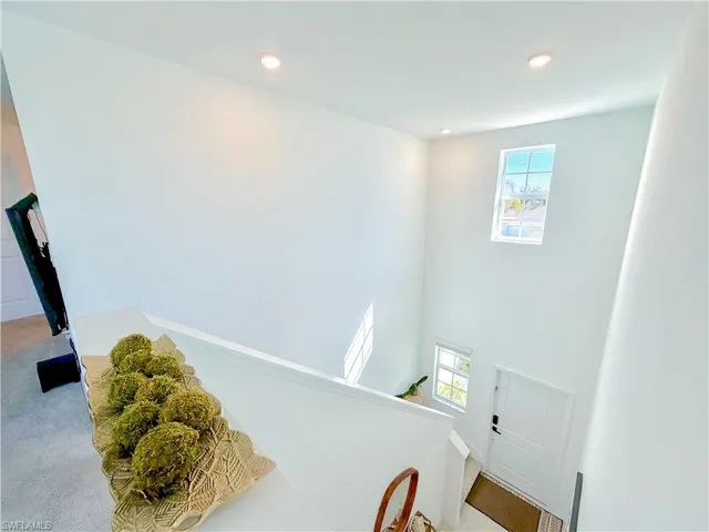 Stairway featuring a high ceiling, recessed lighting, and carpet floors