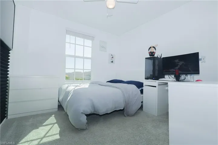 Bedroom with light carpet and a ceiling fan