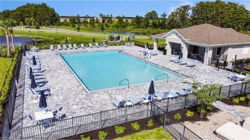 Community pool featuring a patio and view of scattered trees