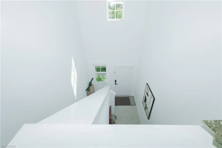 Staircase featuring healthy amount of natural light, a high ceiling, and tile patterned flooring