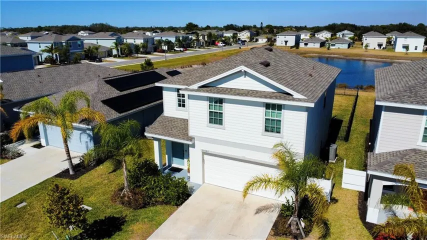 View of front facade with a shingled roof, concrete driveway, a residential view, stucco siding, and a garage