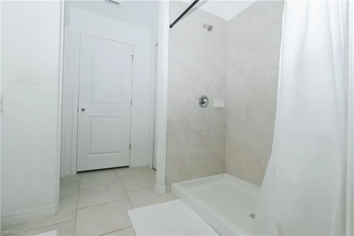 Bathroom featuring a shower stall and light tile patterned floors