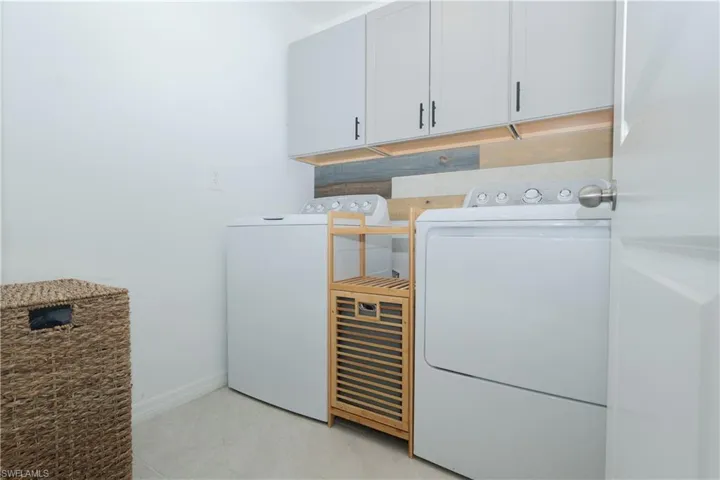 Laundry room featuring independent washer and dryer and cabinet space
