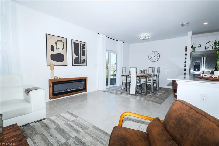 Living area with a glass covered fireplace and light tile patterned floors